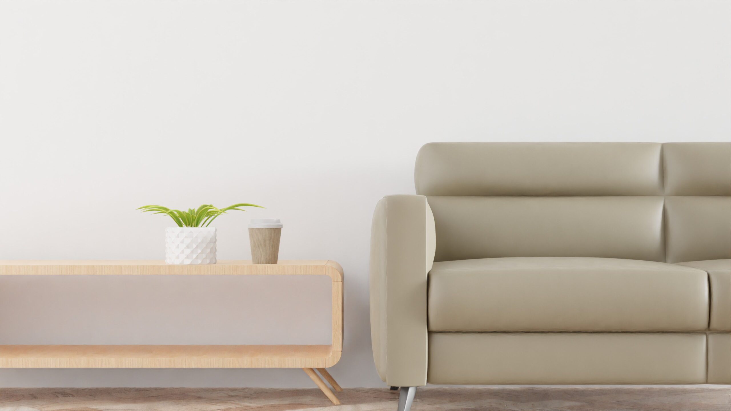 Modern living room with a beige sofa, plant, and coffee cup on a stylish wooden table.